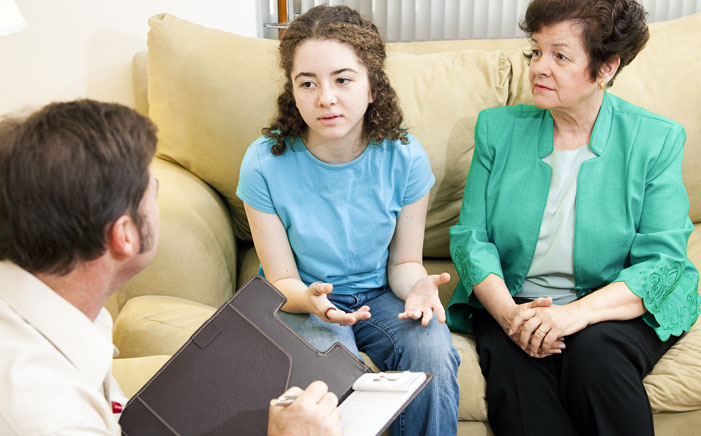 Man counselling young woman, with her grandma accompanying her